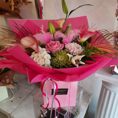 Radiant Pink Box Arrangement - A vibrant boxed arrangement showcasing a mix of bold and soft pink hues, complemented by touches of greenery. This striking design makes a statement and is ideal for special celebrations.