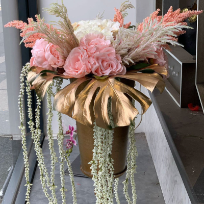 Luxury Gold Vase Arrangement - A sophisticated floral display presented in an elegant gold vase. Soft pastel tones are paired with unique foliage for a luxurious and timeless arrangement that suits any decor.