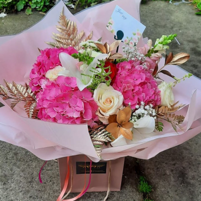 Elegant Blush Bouquet - A beautifully wrapped bouquet featuring a blend of soft pinks and lush greenery. This design exudes elegance and grace, making it a perfect choice for any special occasion.