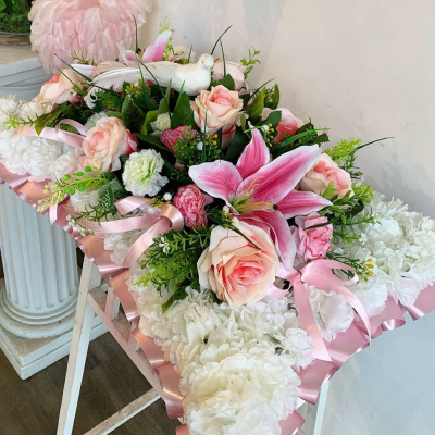 Peaceful Pink Pillow - A graceful pillow arrangement in soothing pink tones, accompanied by subtle greenery. This design is perfect for conveying sympathy and offering a message of peace.