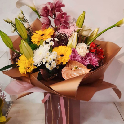 Radiant Beauty Bouquet - This bouquet features a beautiful arrangement of colourful blooms, including yellow, purple, and pink tones. Wrapped in stylish paper, it’s a perfect gift for expressing your appreciation or congratulations.