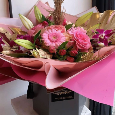 Pink Delight Arrangement - A luxurious pink-themed bouquet with a mix of flowers, wrapped in elegant pink paper. The arrangement is designed to convey feelings of warmth and affection.